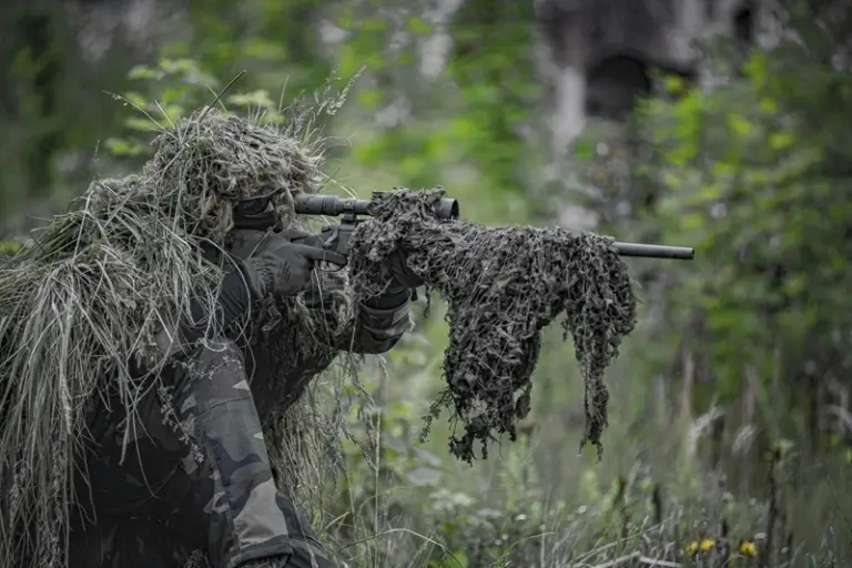 An upgraded airsoft sniper rifle in a ghillie camouflage setup, tuned for maximum range and accuracy.